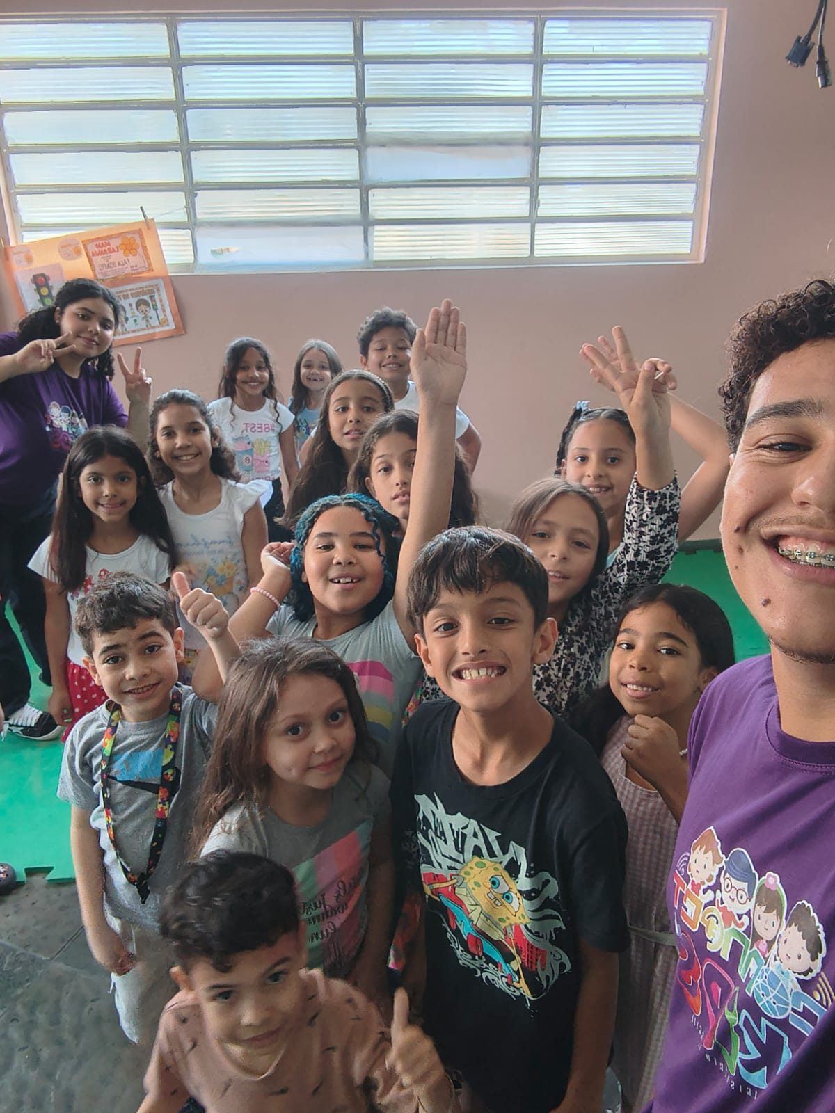 Crianças sorrindo e acenando com um professor