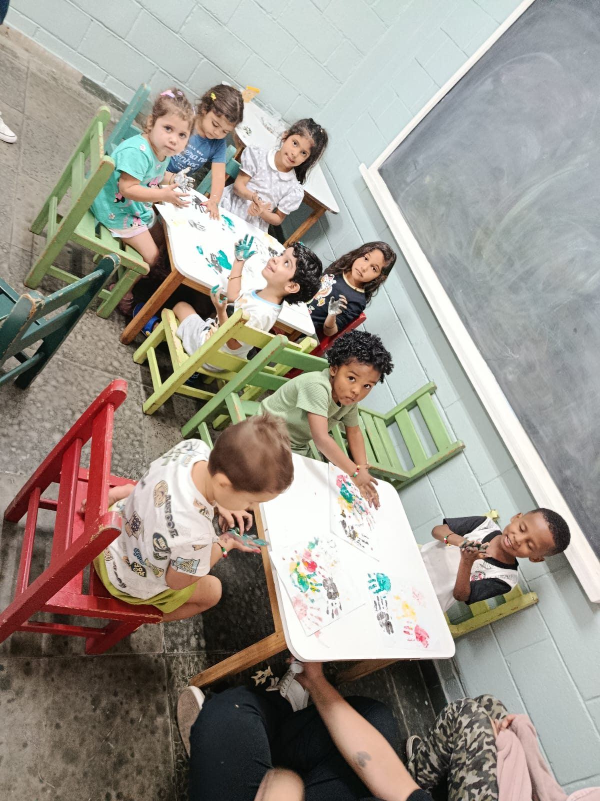 Crianças fazendo pintura com as mãos