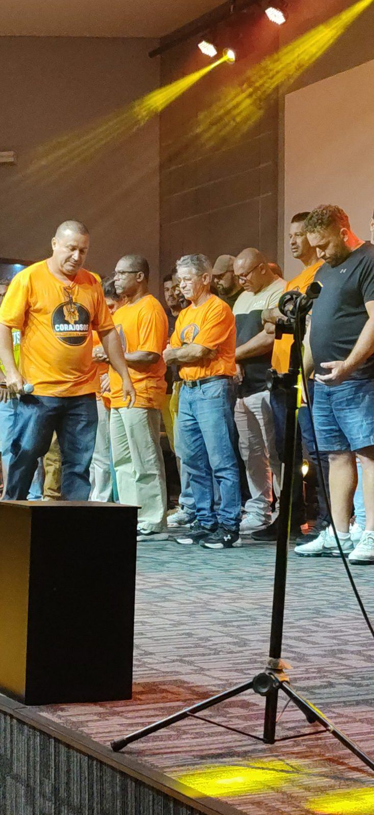 Corajosos em oração no palco